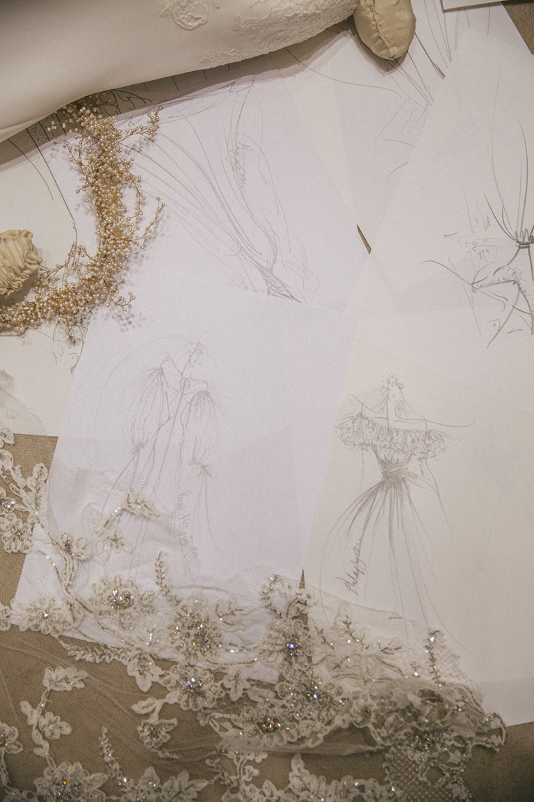 Hand drawn sketches of Rosie Thomas' Phillipa Lepley bespoke wedding gown sitting alongside lace embroidered with crystals.