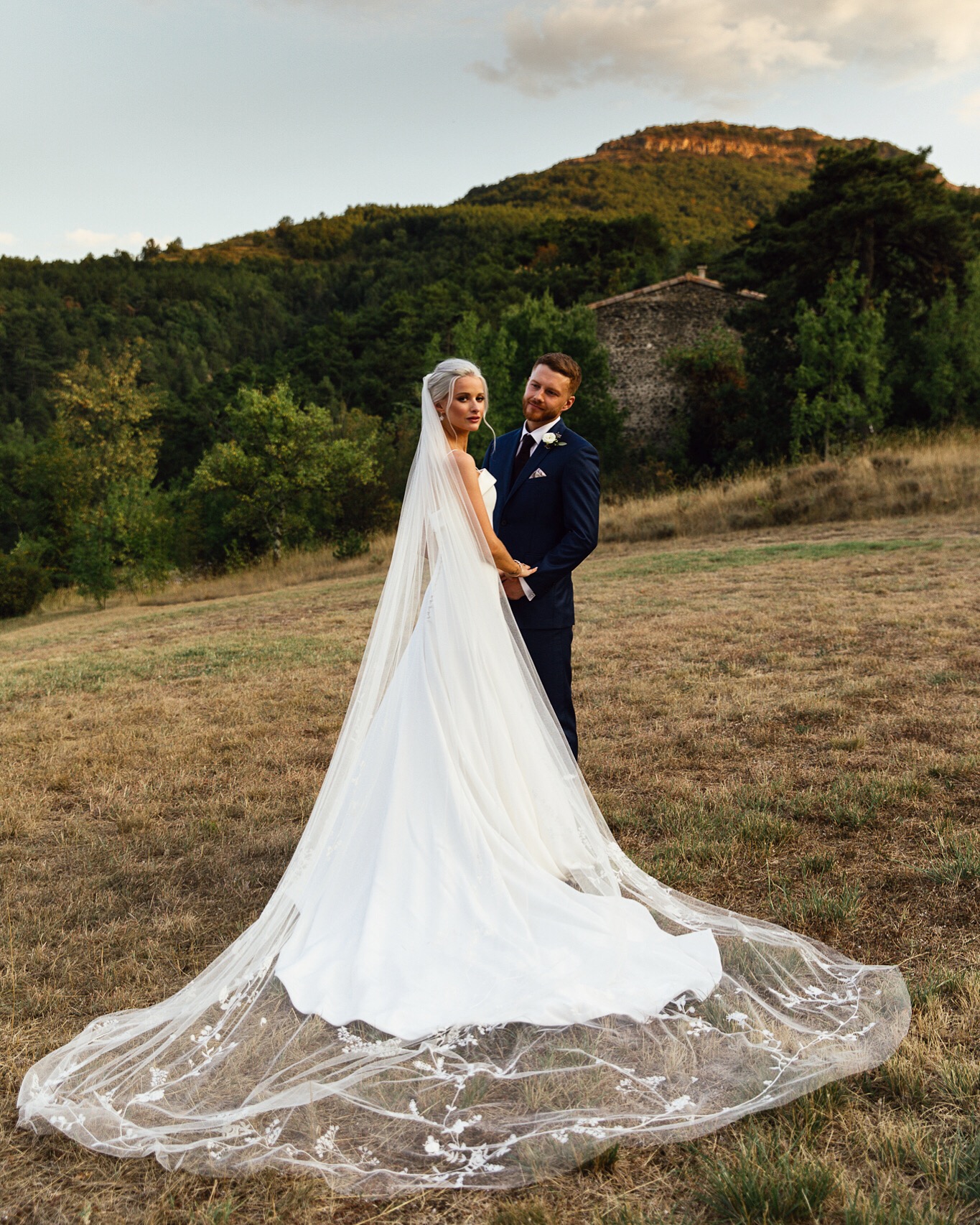 Victoria Magrath of inthefrow stands in Provence countryside with her new husband wearing her wedding dress by Phillipa Lepley